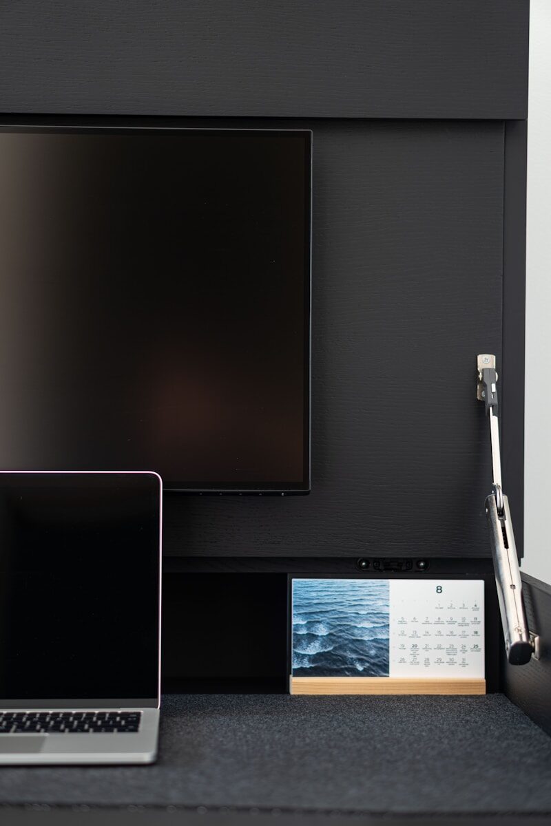 A laptop computer sitting on top of a desk next to a monitor
